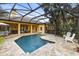 Screened-in pool area with stone decking, lush landscaping, and plenty of seating at 3402 Melissa Country Way, Lutz, FL 33559