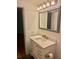 Bathroom vanity featuring white cabinetry, updated fixtures, and decorative mirror at 4020 55Th N St # 1106, Kenneth City, FL 33709