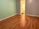 Bedroom with wood-look floors, neutral walls, and view into an ensuite bathroom at 4020 55Th N St # 1106, Kenneth City, FL 33709