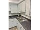 Galley kitchen features stainless steel sink, black countertops and white cabinets at 4020 55Th N St # 1106, Kenneth City, FL 33709