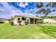 Well-maintained backyard with green grass and screened lanai of home's exterior at 4304 Place Le Manes, Lutz, FL 33558