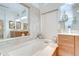 Bright bathroom with a soaking tub, tile walls, and wood cabinets providing ample storage at 4304 Place Le Manes, Lutz, FL 33558