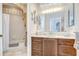Charming bathroom featuring dark wood vanity, large mirror, and shower with tub combination at 4304 Place Le Manes, Lutz, FL 33558