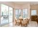 Sunny dining area with a round glass table, seating for four, and sliding glass doors to lanai at 4304 Place Le Manes, Lutz, FL 33558