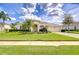 Charming single-story home with a well-manicured lawn and lush, tropical landscaping at 4304 Place Le Manes, Lutz, FL 33558