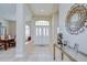 Inviting foyer features neutral tile flooring, transom window above double doors, and decorative mirror at 4304 Place Le Manes, Lutz, FL 33558