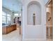 Hallway showcasing decorative niche, view to office with built-in desk, and stylish powder room at 4304 Place Le Manes, Lutz, FL 33558
