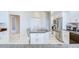 Kitchen featuring island with cooktop, stainless appliances, tile flooring, and ample storage space at 4304 Place Le Manes, Lutz, FL 33558