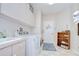 Well-lit laundry room with modern washer and dryer, storage cabinets, and convenient sink at 4304 Place Le Manes, Lutz, FL 33558