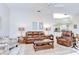 Bright living room with ceiling fan, tile floors, leather furniture, and view to the kitchen at 4304 Place Le Manes, Lutz, FL 33558