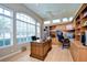Bright office with hardwood floors, custom built-ins, large windows, and a ceiling fan at 4304 Place Le Manes, Lutz, FL 33558