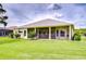 View of screened-in patio with dining and ceiling fan overlooking a pristine lawn at 4304 Place Le Manes, Lutz, FL 33558
