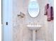 Charming powder room with pedestal sink, ornate mirror, and decorative wallpaper at 4304 Place Le Manes, Lutz, FL 33558