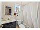 Clean, simple bathroom featuring a white shower curtain and black vanity at 44 77Th Ave, Treasure Island, FL 33706