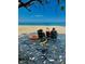 Relaxing scene with beach chairs, a beautiful ocean view and shady tree branch overhead at 44 77Th Ave, Treasure Island, FL 33706