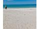 Person walking on a tranquil beach scene with clear blue water at 44 77Th Ave, Treasure Island, FL 33706