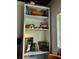Rustic white bookcase displaying an array of books, vintage art, and charming decorative items, adding character to the space at 44 77Th Ave, Treasure Island, FL 33706