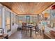 Bright sunroom with rustic wood ceiling and walls of windows at 44 77Th Ave, Treasure Island, FL 33706