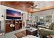Comfortable living room featuring a large screen TV, wooden ceiling, and an adjacent sitting area at 44 77Th Ave, Treasure Island, FL 33706