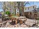 Inviting outdoor dining area featuring a rustic wooden table and benches, surrounded by lush greenery and a charming brick patio at 44 77Th Ave, Treasure Island, FL 33706