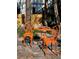 Charming outdoor seating area features decorative metal chairs and a table, set on a patterned stone patio surrounded by trees at 44 77Th Ave, Treasure Island, FL 33706