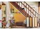 Unique under-stairs space with bright yellow walls, decorative items, and a cozy reading nook at 44 77Th Ave, Treasure Island, FL 33706