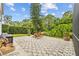 A backyard with a patterned paved patio, complete with outdoor furniture and lush greenery surrounding the space at 4505 Anaconda Dr, New Port Richey, FL 34655