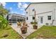 A backyard with a patio featuring outdoor furniture and an angled view of the screened pool enclosure and landscaping at 4505 Anaconda Dr, New Port Richey, FL 34655