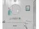 Bright bathroom featuring a white vanity with marble countertop and a round mirror at 4505 Anaconda Dr, New Port Richey, FL 34655