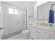 Stylish bathroom with a glass-enclosed shower, white vanity, and stone-look shower floor at 4505 Anaconda Dr, New Port Richey, FL 34655