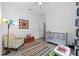 Well-lit Bedroom featuring a soft chair and crib with colorful details at 4505 Anaconda Dr, New Port Richey, FL 34655