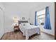 Cozy bedroom with wood-look flooring, bright window with blue curtains, and comfortable furnishings at 4505 Anaconda Dr, New Port Richey, FL 34655