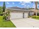 Spacious three-car garage with a long driveway, set against a backdrop of well-manicured landscaping at 4505 Anaconda Dr, New Port Richey, FL 34655
