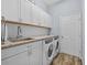 Well-lit laundry room with granite countertop, cabinets, a sink, and modern washer and dryer at 4505 Anaconda Dr, New Port Richey, FL 34655