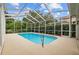 Inviting screened-in pool surrounded by lush greenery and a concrete deck, perfect for relaxing at 4505 Anaconda Dr, New Port Richey, FL 34655