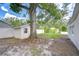 Spacious backyard featuring a large tree, storage shed, and white vinyl privacy fence at 4605 W Loughman St, Tampa, FL 33616