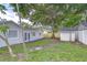Spacious backyard featuring a large tree, storage shed, and privacy fence at 4605 W Loughman St, Tampa, FL 33616
