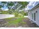 Wide open backyard with manicured green lawn, white fence, and lush landscaping at 4605 W Loughman St, Tampa, FL 33616