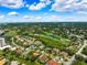 Wide aerial perspective of a residential area adjacent to a lush green golf course and community park at 5904 Pelican Bay S Plz, Gulfport, FL 33707