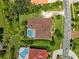 Aerial shot of backyard featuring a sparkling pool, lush landscaping, and a well-maintained roof at 5904 Pelican Bay S Plz, Gulfport, FL 33707
