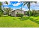 Beautiful home with a lush green lawn, palm trees, and tropical landscaping at 5904 Pelican Bay S Plz, Gulfport, FL 33707
