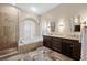Bathroom with double sink vanity, soaking tub, separate shower, and arched window with shutters at 5904 Pelican Bay S Plz, Gulfport, FL 33707