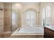 Bathroom with soaking tub, separate shower, and arched window with shutters at 5904 Pelican Bay S Plz, Gulfport, FL 33707