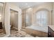 Bathroom with soaking tub, separate shower, and arched window with shutters at 5904 Pelican Bay S Plz, Gulfport, FL 33707