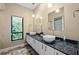 Bathroom featuring dual vessel sinks, granite countertops, and a large window with tropical views at 5904 Pelican Bay S Plz, Gulfport, FL 33707
