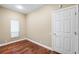 Bedroom featuring hardwood floors, a window, and a white door at 5904 Pelican Bay S Plz, Gulfport, FL 33707