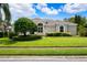 Attractive home showcasing a beautiful lawn, neatly trimmed shrubs, and a stately architectural design at 5904 Pelican Bay S Plz, Gulfport, FL 33707