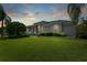 Elegant home with lush greenery, mature trees, and a serene setting enhanced by the tranquil sunset at 5904 Pelican Bay S Plz, Gulfport, FL 33707