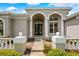 Inviting front entrance with double doors, elegant columns, and meticulously landscaped pathway, creating curb appeal at 5904 Pelican Bay S Plz, Gulfport, FL 33707