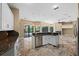Open kitchen with white cabinets, granite counters, and stainless steel appliances perfect for entertaining at 5904 Pelican Bay S Plz, Gulfport, FL 33707
